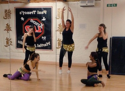 class members laughing and rehearsing for bellydance show